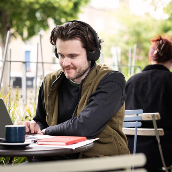 Blended Student working on college work outside Cafe 